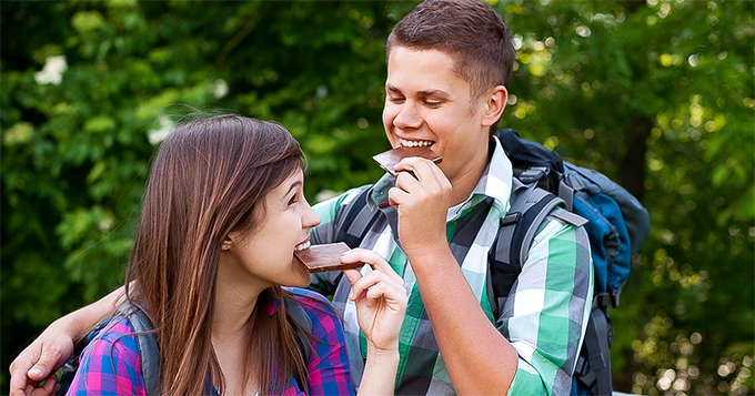 A couple enjoying bars of chocolate | Trainest