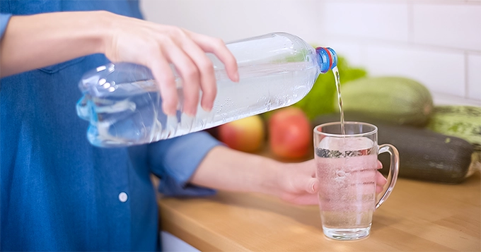 Someone pouring soda water into glass | Trainest