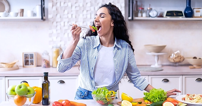 Someone happily eating a salad | Trainest