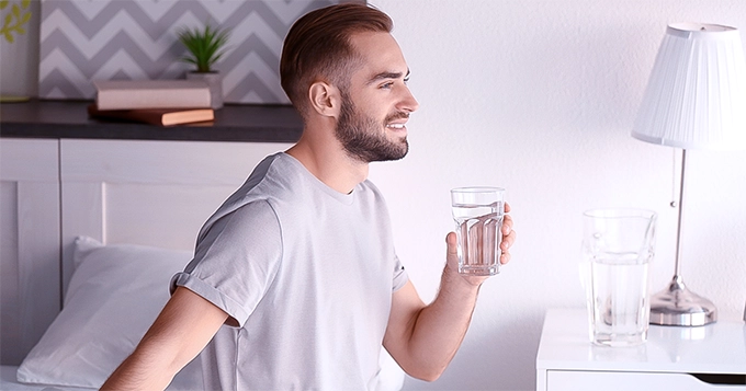 A man drinking water in the morning | Trainest