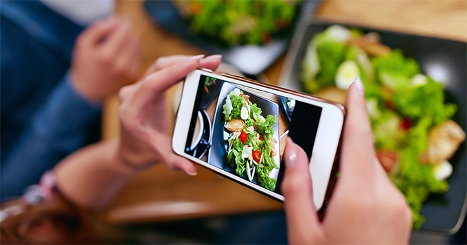 Someone taking a photo of their meal | Trainest