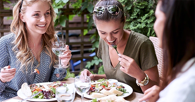 Friends eating together outdoors | Trainest