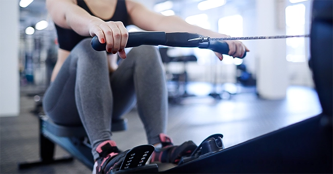 A woman on a rowing machine | Trainest