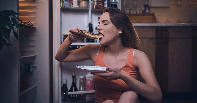 A woman late night-snacking | Trainest