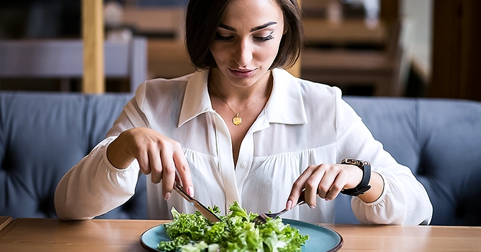 A woman eating salad | Trainest