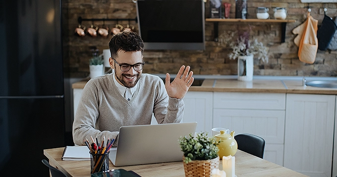 A man happily working in front of the computer | Trainest