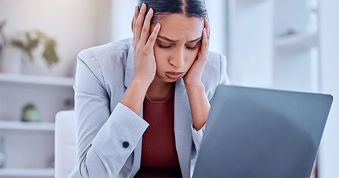 A woman looking stressed in the office | Trainest 