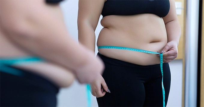 A woman measuring her waist circumference | Trainest