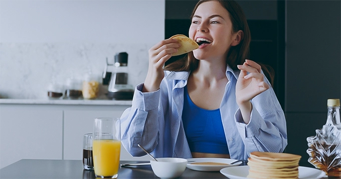 A woman eating breakfast | Trainest