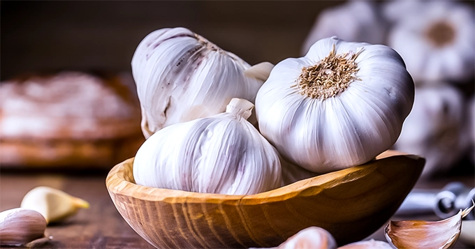 Heads and cloves of garlic on a table | Trainest