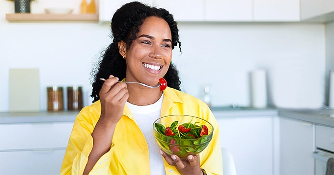 A woman eating a healthy meal | Trainest