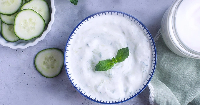 A bowl of yogurt and sliced cucumbers | Trainest 