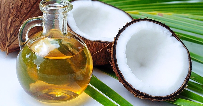 A coconut and a bottle of coconut oil | Trainest 