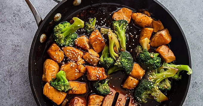 A pan of salmon and broccoli stir-fry | Trainest 