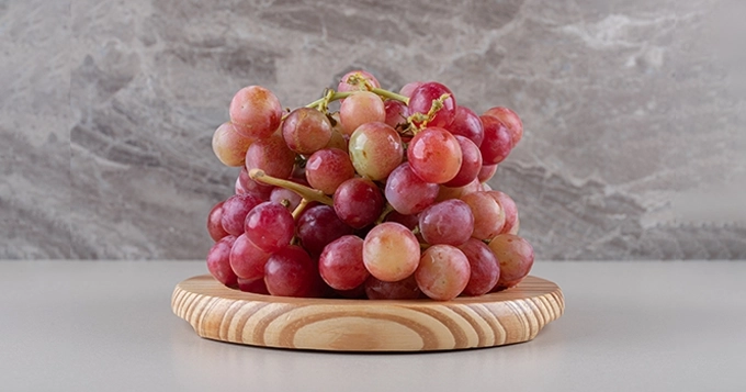 A bunch of red grapes on a plate | Trainest 