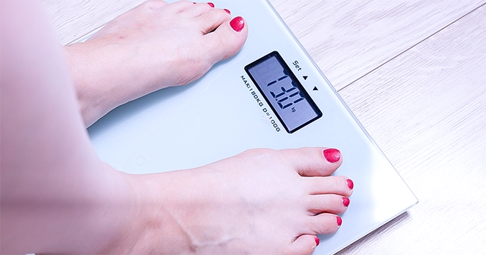 A close-up of a woman on a weighing scale | Trainest 