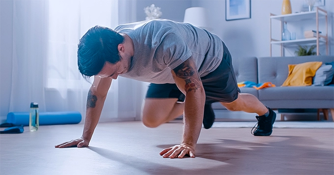 A man doing mountain climbers at home | Trainest 