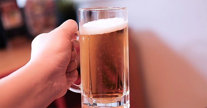 Someone holding a mug of beer | Trainest 