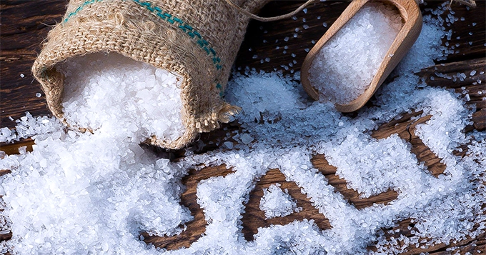 A bag of coarse salt scattered on a table | Trainest 