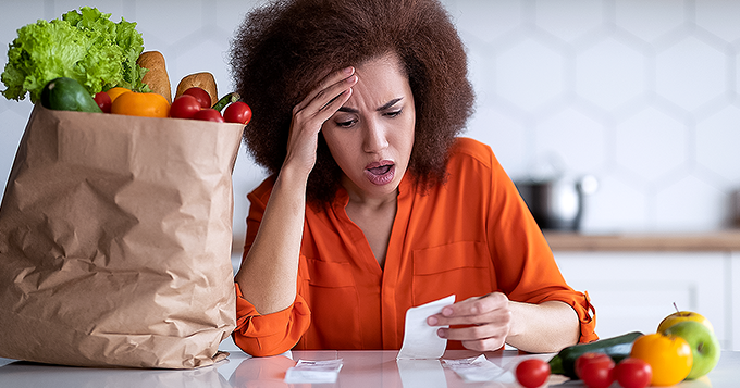 A woman distressed while checking her grocery bill | Trainest 