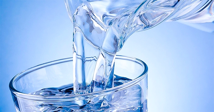 A close-up of water being poured into a glass | Trainest 