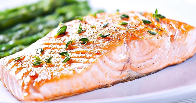 A seared salmon filet on a plate | Trainest 