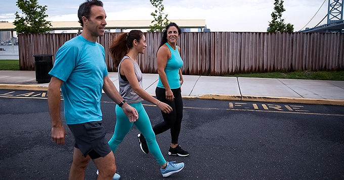 A trio of people in gym clothes walking around the neighborhood | Trainest 