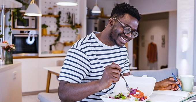 A happy man eating a healthy meal | Trainest 