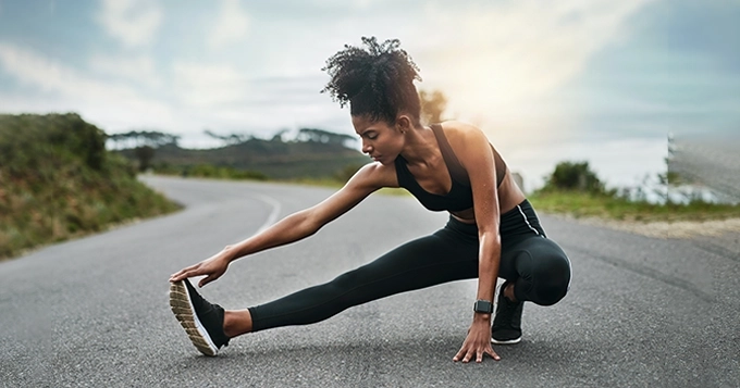 An athlete stretching outdoors | Trainest 