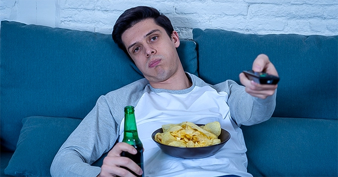 A couch potato consuming junk | Trainest 