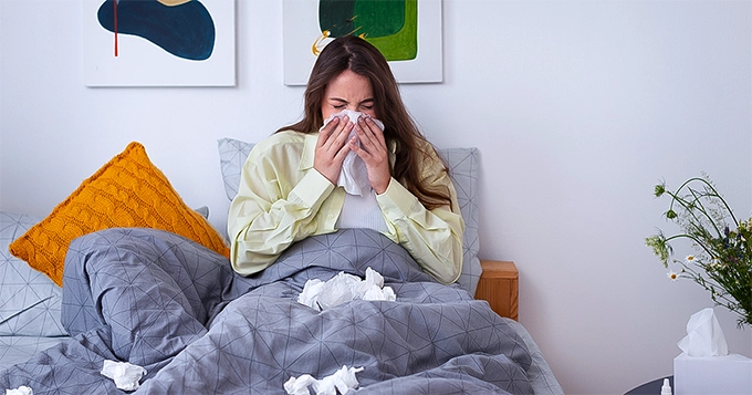 A woman in bed, down with the flu | Trainest 