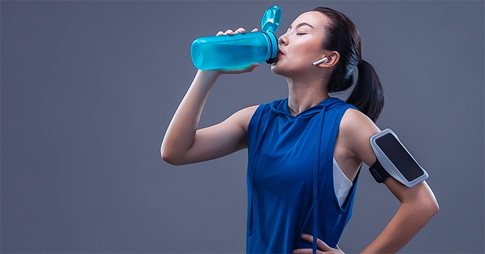 A fit person hydrating | Trainest 