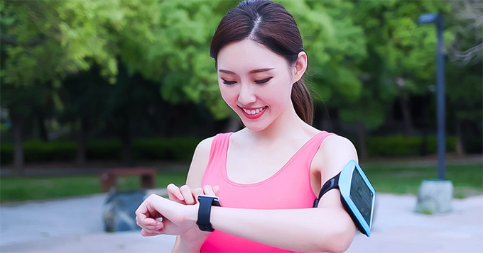 A active-looking woman using a smartwatch | Trainest 