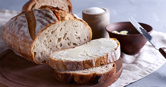 Sliced sourdough bread with butter | Trainest 