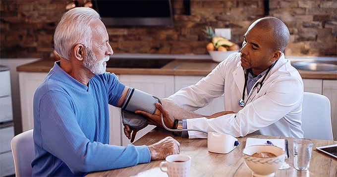 A doctor checking a patient's blood pressure | Trainest 