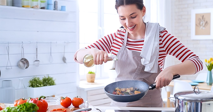 A woman cooking healthy food | Trainest 