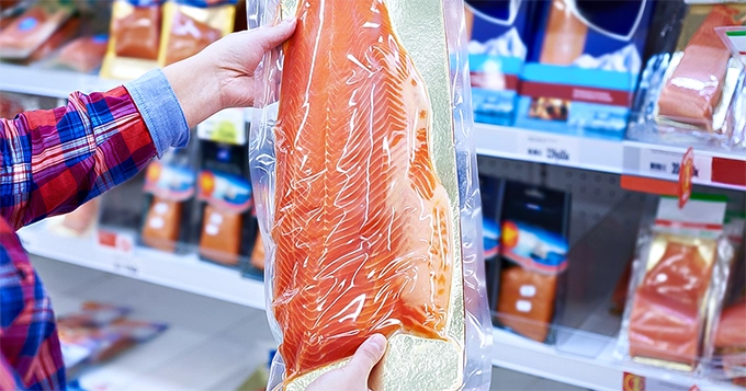 A person holding a pack of salmon | Trainest 