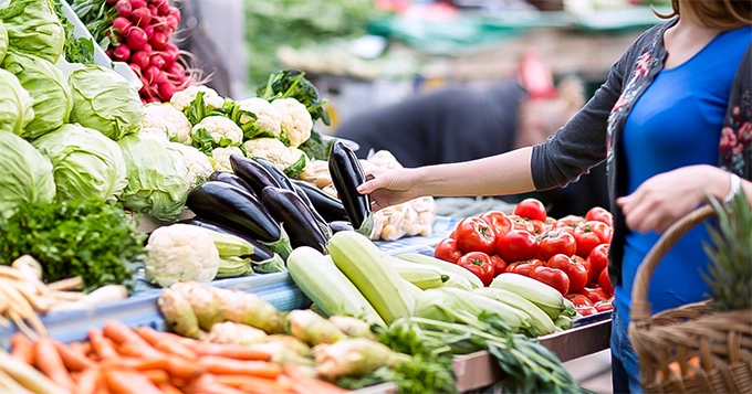 A woman browsing fresh vegetables | Trainest 