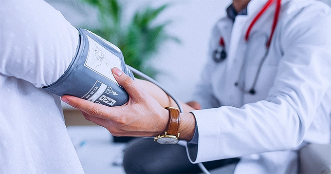 Doctor measuring patient's blood pressure | Trainest 