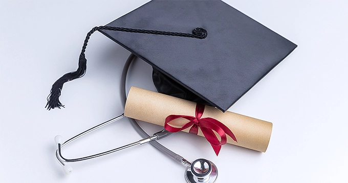 A graduation cap, diploma, and stethoscope | Trainest 