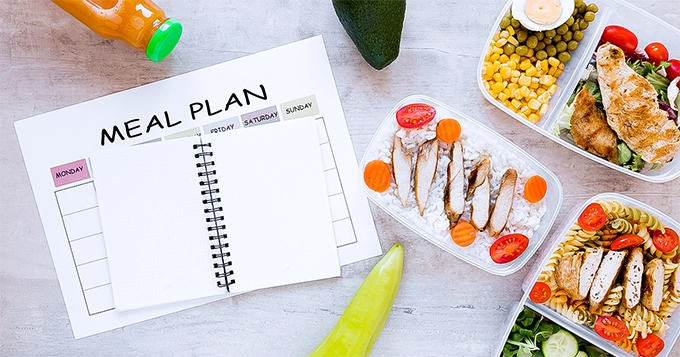 A table with prepped meals and a meal plan | Trainest 