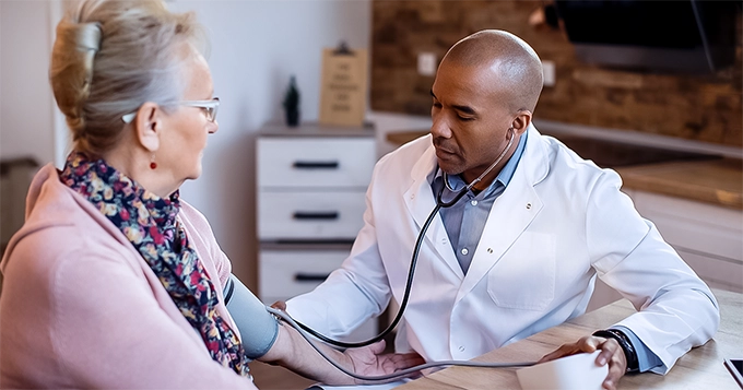 A doctor measuring blood pressure of an elderly woman | Trainest 