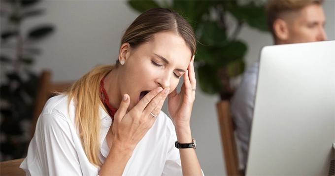 A sleepy woman in the office | Trainest 