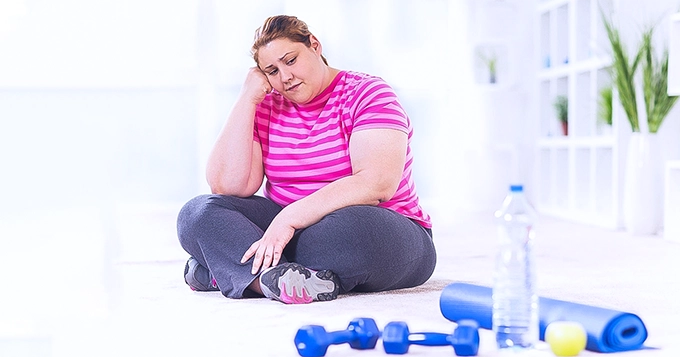 An overweight woman looking frustrated | Trainest