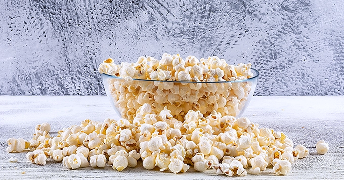 An overflowing bowl of plain popcorn | Trainest
