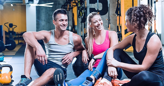 A group of people having a fun conversation in the gym | Trainest
