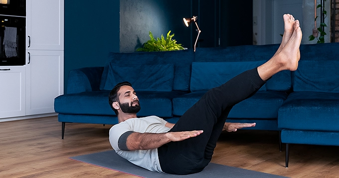 A man working out in the living room | Trainest 