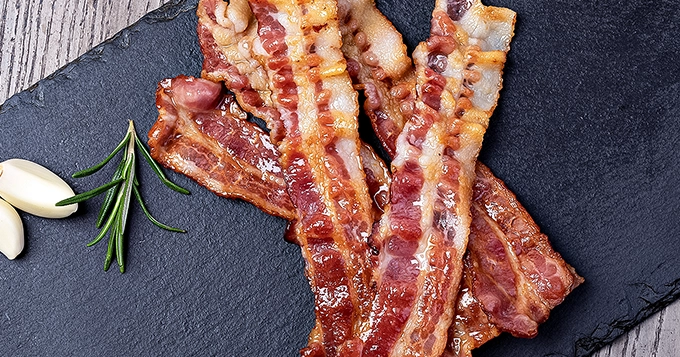 Strips of cooked bacon on a serving tray | Trainest 