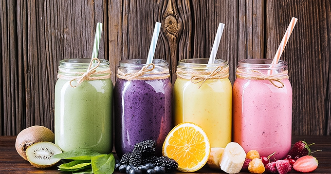 Several glasses of differently-colored fruit smoothies | Trainest 