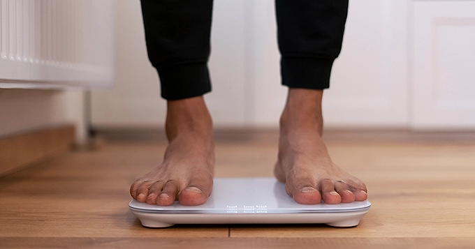 Someone stepping on a smart scale | Trainest 